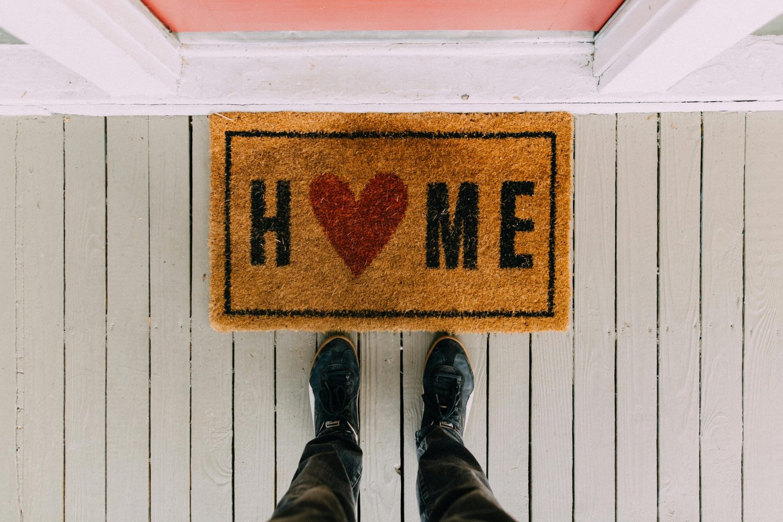 Home A creative doormat with heart motif symbolizing home at a front porch entrance.